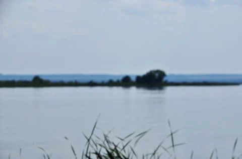 Blurred background, view of a large lake with an island. No focus, lake. Stock Photos