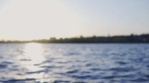 Blurred background of water waves on the shore at sunny sunset Stock Footage 128731172
