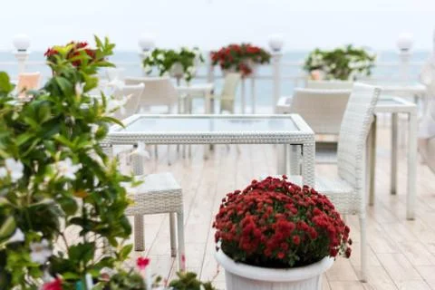 Blurred background,empty tables and chairs of a restaurant on a terrace overl Stock Photos