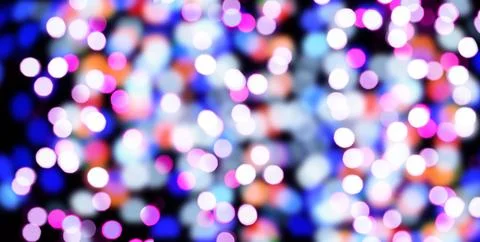 A blurred black background with bright circular bokeh lights in blue, purpl.. Stock Photos