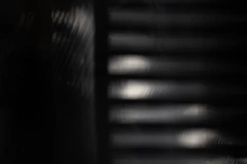 Blurred black background with soft horizontal light bands and mesh shadow f.. Fotos Stock