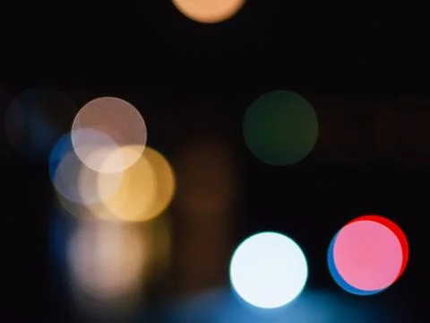 Blurred bokeh on dark background from bright lights of night city Stock Photos