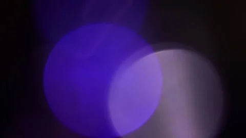 Blurred bokeh light dances in the blue and purple darkness. Видео 309964229