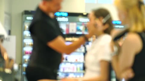 Blurred bokeh video. Makeup lesson. Makeup artist and beautiful brunette girl Stock Footage 64348308