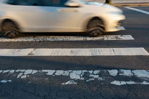Blurred car speeding through a pedestrian crossing. Traffic sign. Stockfoto's