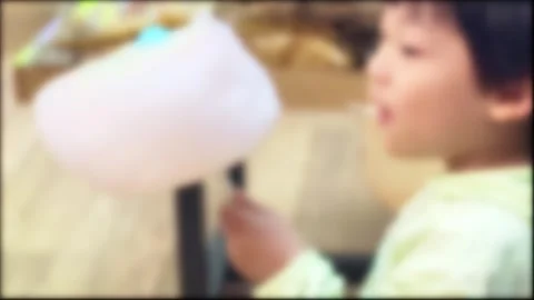 Blurred, a child who eats sweet cotton candy deliciously Stock Footage 275899840