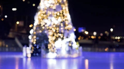 Blurred Christmas tree in bokeh effect with Garland lights blinking on ice rink Stock Footage 122006295