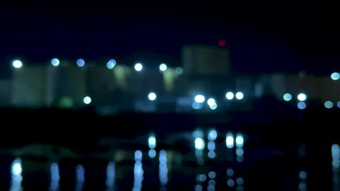 Blurred cityscape with glowing lights against a dark night sky reflecting o.. Stock Footage 340220742