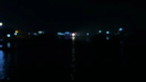Blurred cityscape at night with glowing lights reflecting on dark water und.. Stock-Footage 340052534