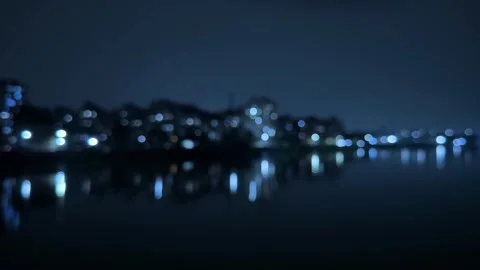 Blurred cityscape at night with reflections of lights on a calm water surfa.. Stock Footage 340052532