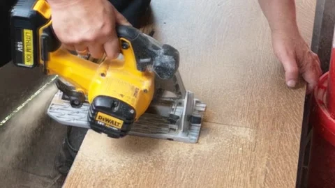 Blurred close up man's hands on home balcony sawing off piece of board,jigsaw Stock Footage 156573758