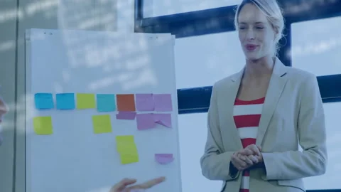 Blurred code fading as man gesturing flipchart and presenter explaining colorful Stock Footage 310644187