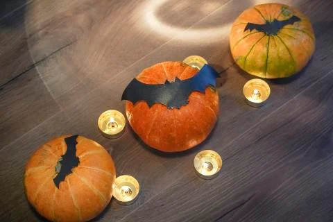 Blurred composition for helloween, three pumpkins, bats and candles Stock Photos