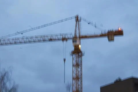 Blurred construction crane at dusk Stock Photos