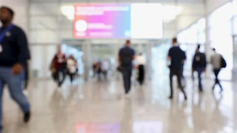 Blurred convention hallway with display and crowd of people passing Stock Footage 124525909