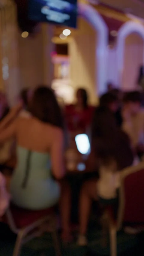 Blurred crowd moving through purple lit indoor venue with colorful lights and Stock Footage 345528480