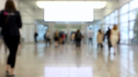 Blurred crowd of people walking through shot in one direction at a trade fair Stock Footage 123835244