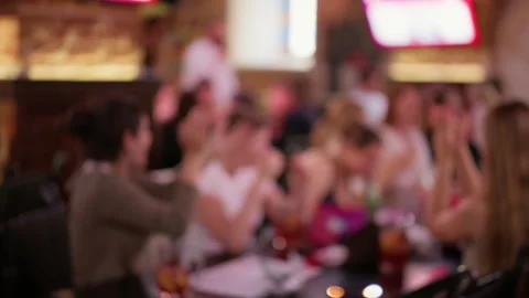 Blurred crowd socializing inside lively bar with warm lights and colorful Stock Footage 345265561