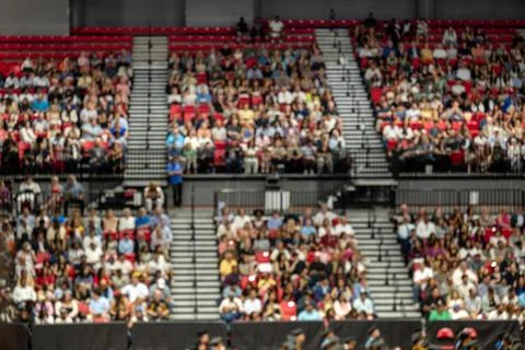 Blurred crowd of spectators sitting in stadium stands during large public event Stock Photos
