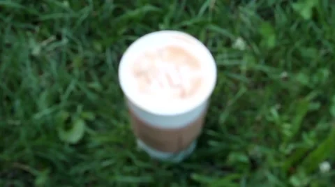 BLURRED CUP OF COFFEE ON THE GREEN GRASS IN LVIV UKRAINE Video stock 65416664
