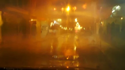 Blurred defocus footage of raining on front mirror of car parking on street   Stock Footage 98894252