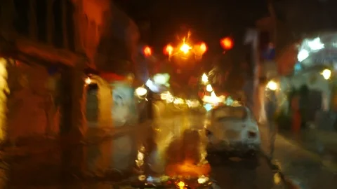 Blurred defocus footage of raining on front mirror of car parking on street   Stock Footage 98895468