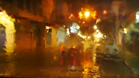 Blurred defocus footage of raining on front mirror of car parking on street   Stock Footage 98895499