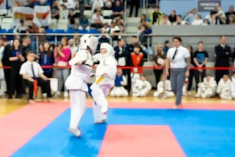Blurred defocused image with two karate practitioners sparring on a tatami ma Fotos Stock