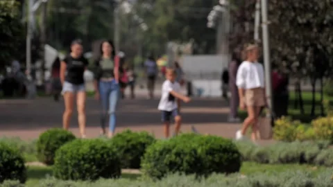 Blurred defocused people going in the central park of the city Stock Footage 204092731