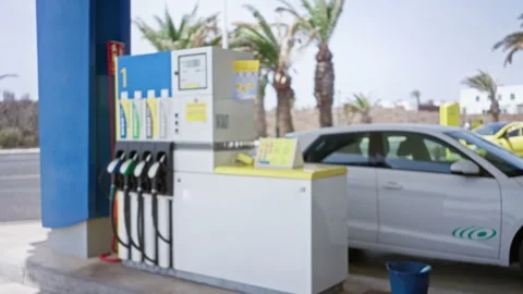 Blurred, defocused view of a petrol station with gas pumps, a white car par.. Stock Footage 289326977