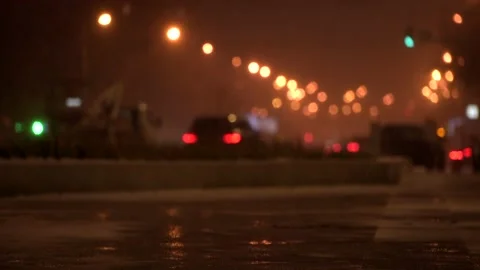 Blurred defocused view on winter road with traffic and falling snow Stock Footage 143528024