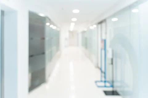 Blurred empty open space corridor. Abstract light bokeh at office interior Stock Photos