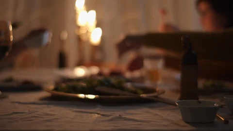 Blurred evening dinner with candle lights. Hands taking food and drinks in slow Stock Footage 119066757