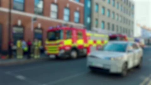 Blurred fire engines with flashing emergency lights outside urban building Video stock 342334621
