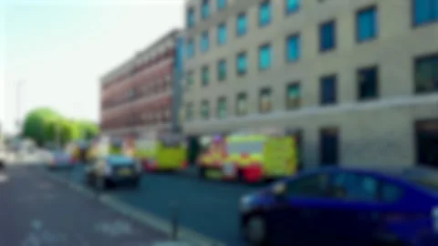 Blurred fire engines parked along city street with passing traffic during Stock Footage 343511642