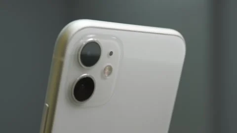 Blurred to focus. White phone with two lens camera on the back. Technology Video stock 250515527