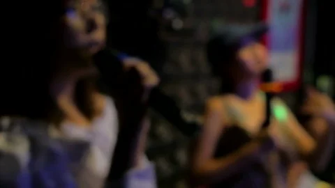 Blurred footage of friends having fun with singing karaoke party. Stock Footage
