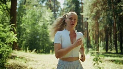 Blurred foreground of a runner in motion through a green forest Stock Footage 346662816