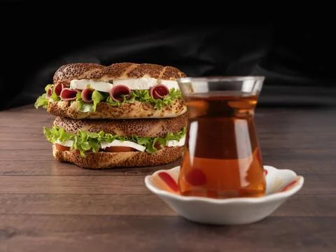 Blurred glass of black to before stack of two delicious simit sandwiches Stock Photos