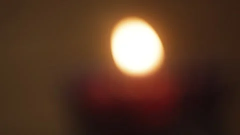 Blurred glowing candle flame with warm orange bokeh, abstract soft light Stock Footage 321048874