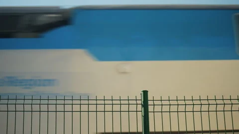 Blurred high speed train passing behind metal fence Stock Footage 337034935