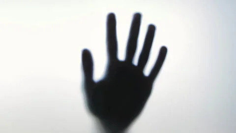 Blurred human hand gradually gaining sharp focus behind frosted glass panel Stock Footage 306948879