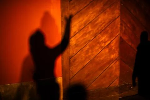 Blurred human shadow with raised arm on wall Stock Photos
