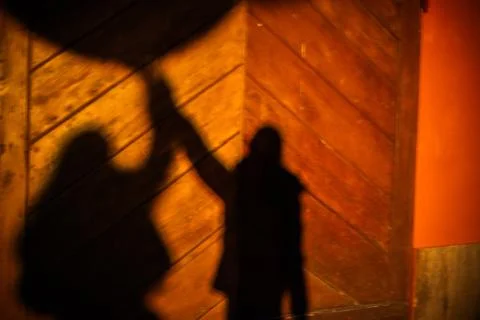 Blurred human shadows on orange wall Stock Photos