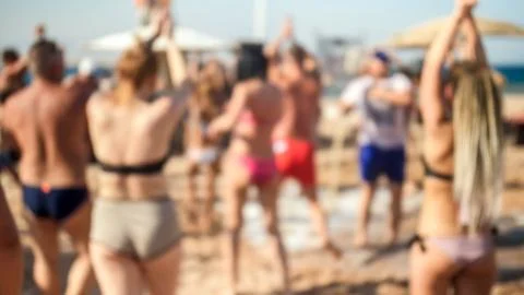 Blurred image of big crowd dancing on the sea beach on summer holiday vacation Stock Photos