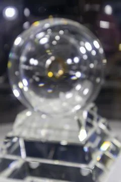 Blurred image of a clear crystal circle on a black background stand. Stock Photos