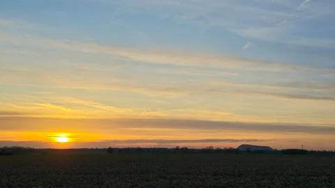 Blurred image of cumulus clouds over a field during sunrise Wunstorf Stock Photos