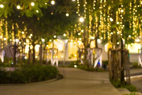 Blurred image Decorative outdoor string lights hanging on tree in the garden Stock Photos