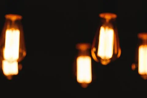 Blurred image of glowing retro light bulbs at night. Stock-Fotos