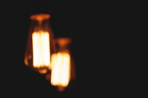 Blurred image of glowing retro light bulbs at night. Stock-Fotos